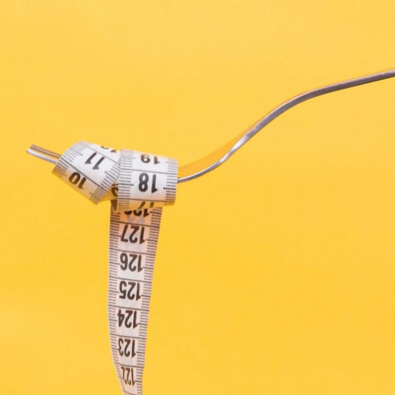 Tape measure around fork representing motivation for weight management